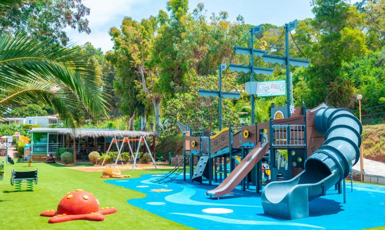 Aire de jeux colorée avec toboggans, balançoires et structures de jeu nautiques.