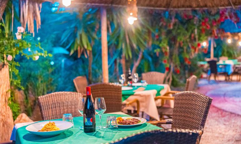 Restaurant en plein air avec tables dressées et vin.