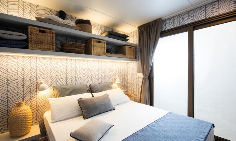 Chambre moderne avec étagères et coussins bleus.
