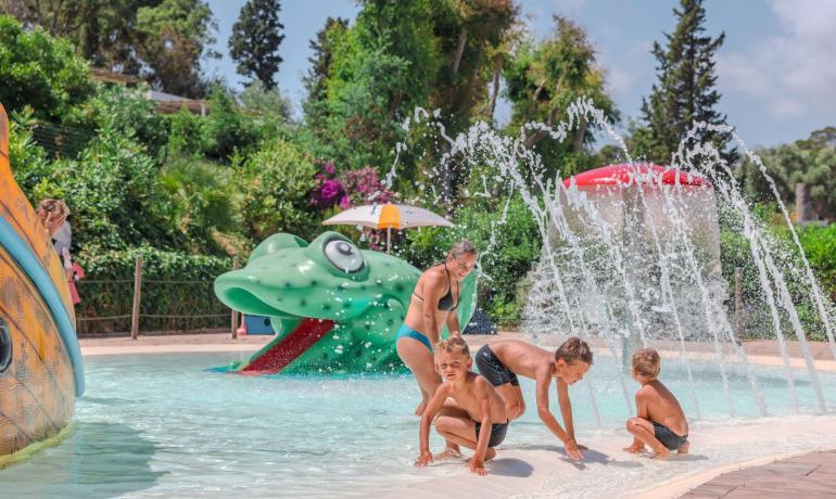 Des enfants jouent dans une piscine avec des sculptures d'eau.
