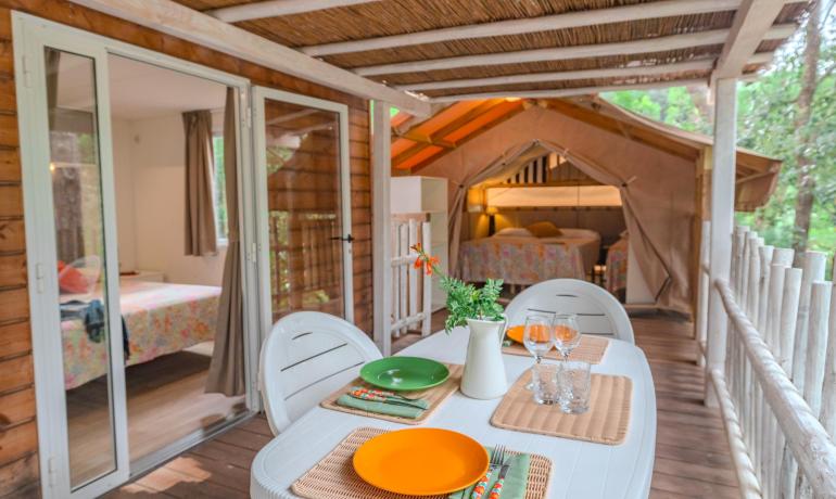 Rustikale Veranda mit gedecktem Tisch und gemütlichen Schlafzimmern.