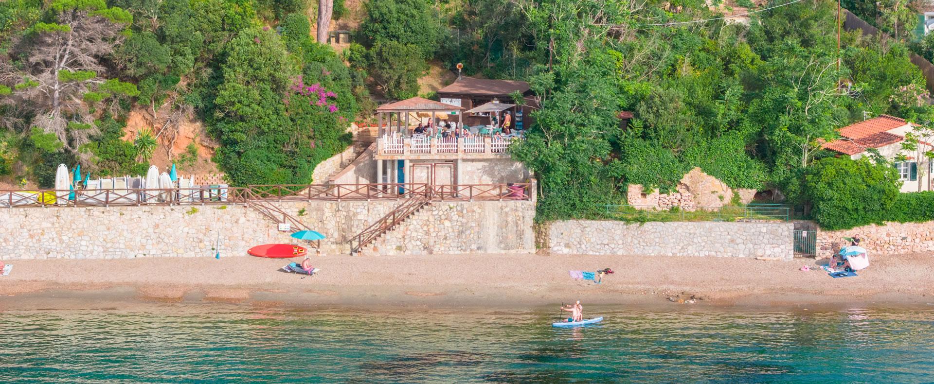 Spiaggia tranquilla, mare calmo, bar accogliente immerso nel verde.